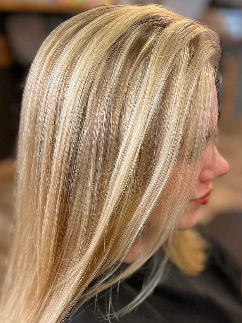 Blonde hair with smooth, straight style in a salon setting.